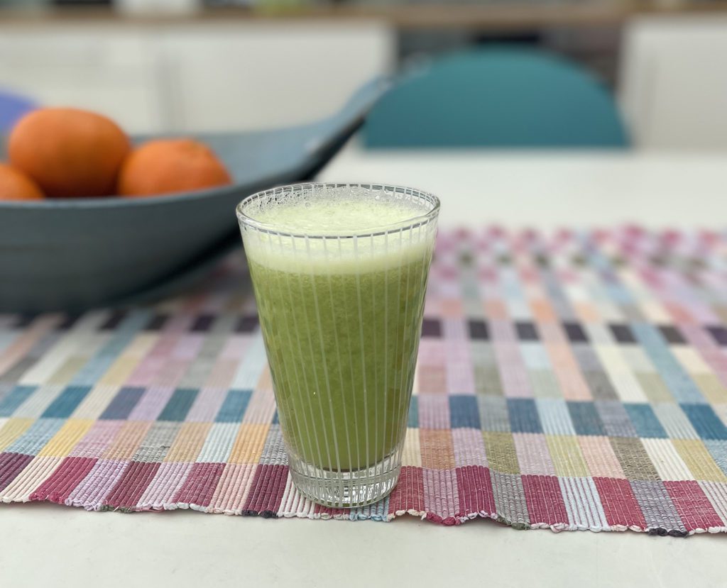 Green smoothie in a glass on a checked tablecloth