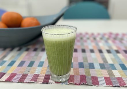 Green smoothie in a glass on a checked tablecloth